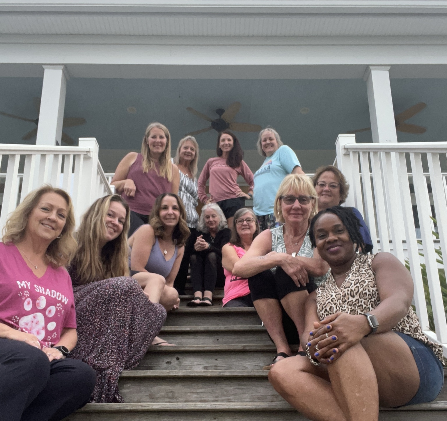 A candid moment of women gathered together on a porch staircase
