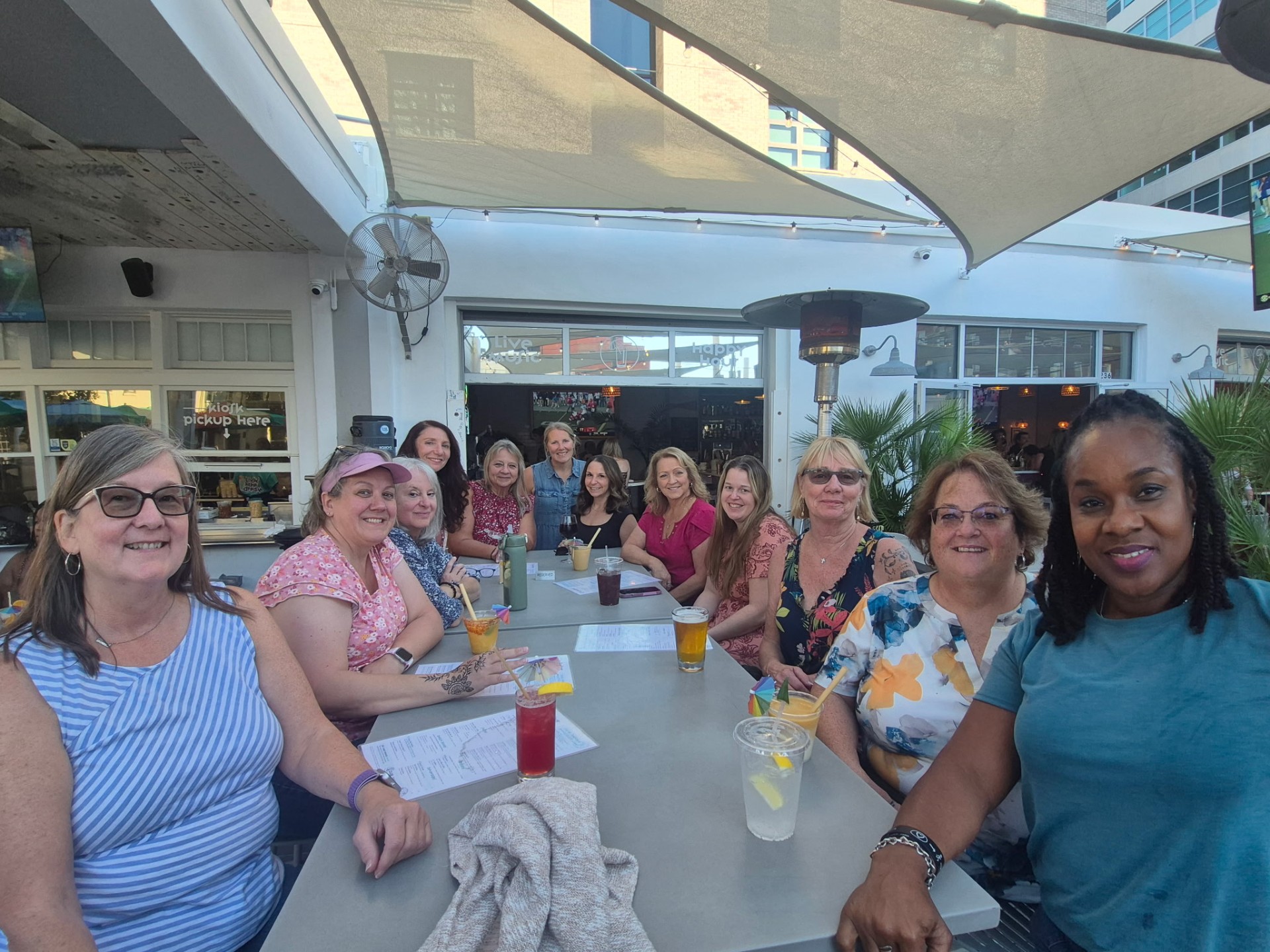 Women laughing together around a patio table