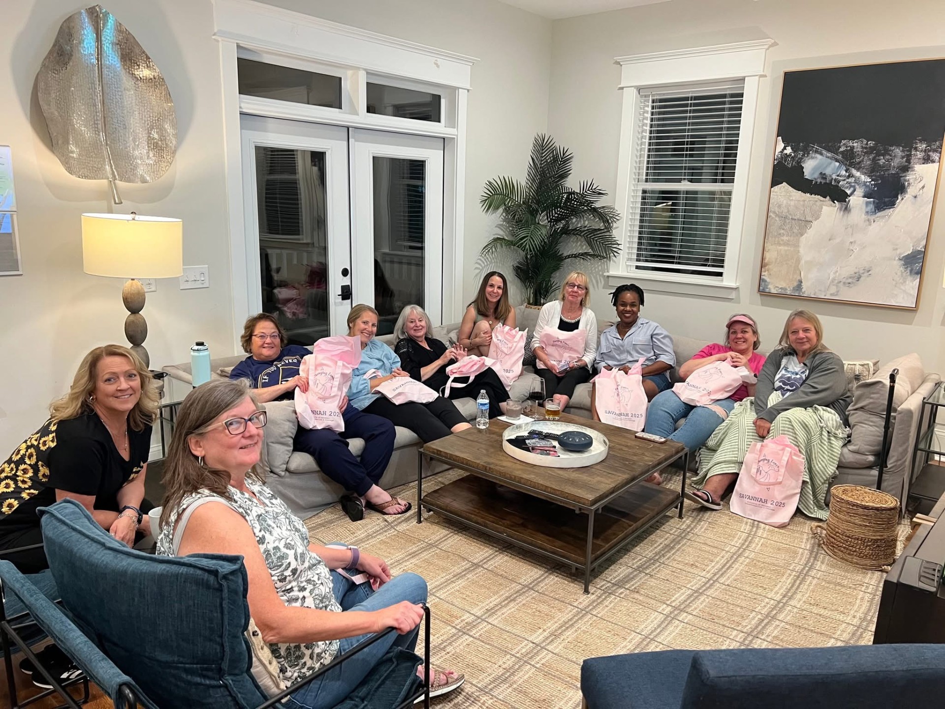 Women gathered in a cozy living room, sharing conversation and welcome gifts